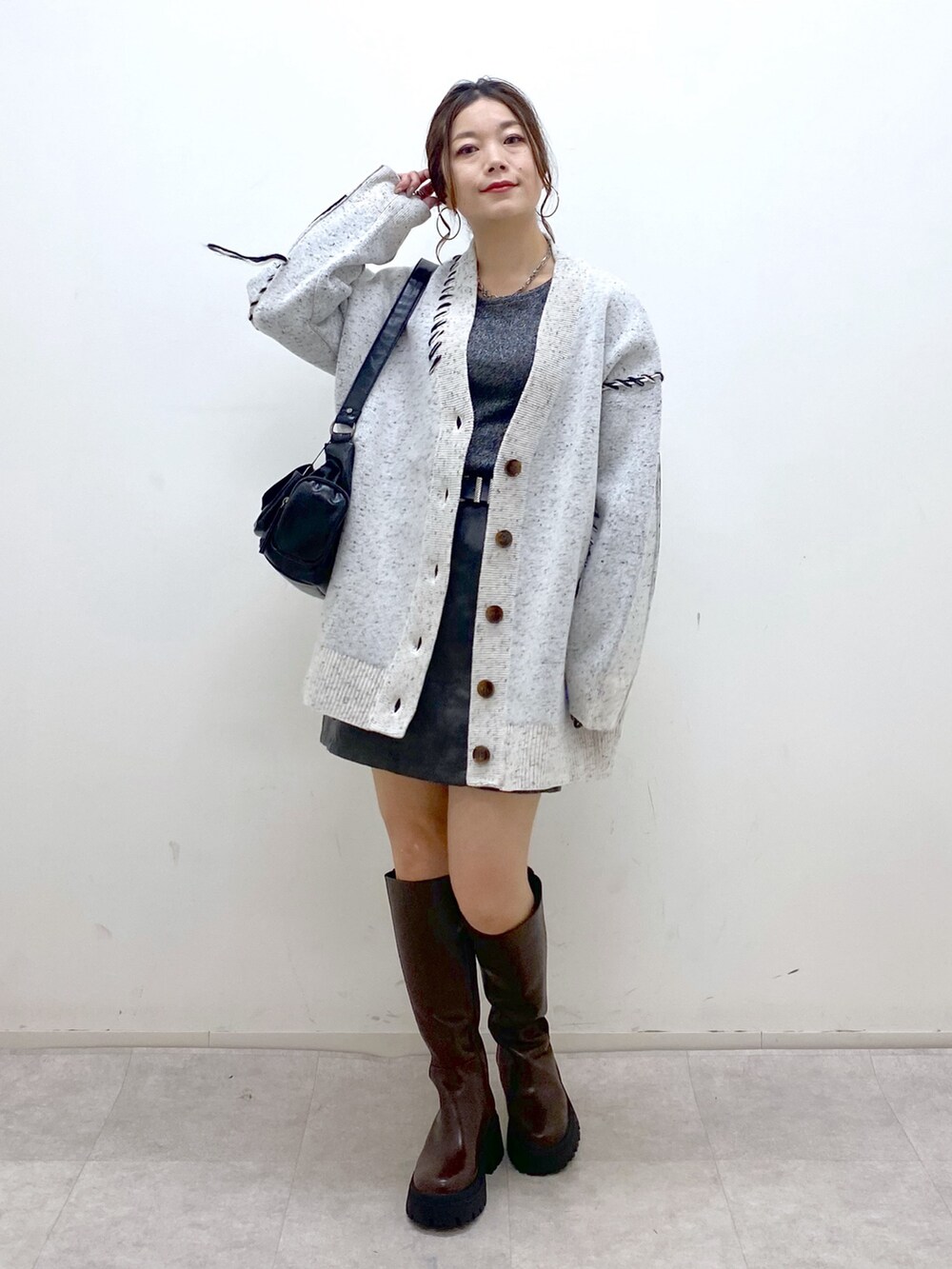 ホワイト系のニット/セーター、シルバー系のTシャツ/カットソー、ブラック系のスカートを着用したレディースの秋コーディネートの9枚目の写真