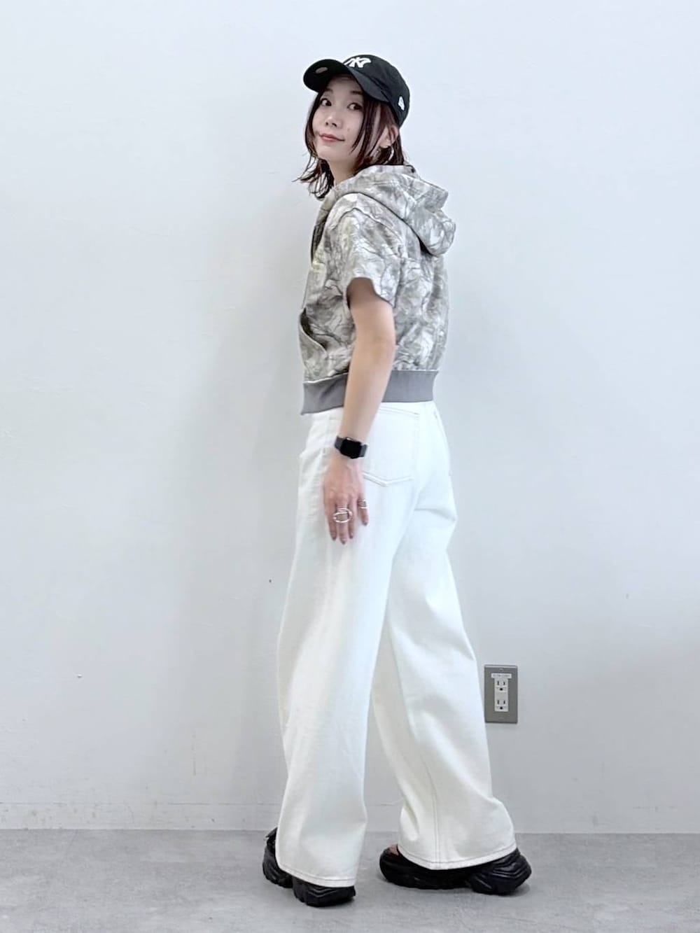 ホワイト系のデニムパンツ、ブラック系のサンダル、その他のパーカーを着用したレディースの春コーディネートの6枚目の写真