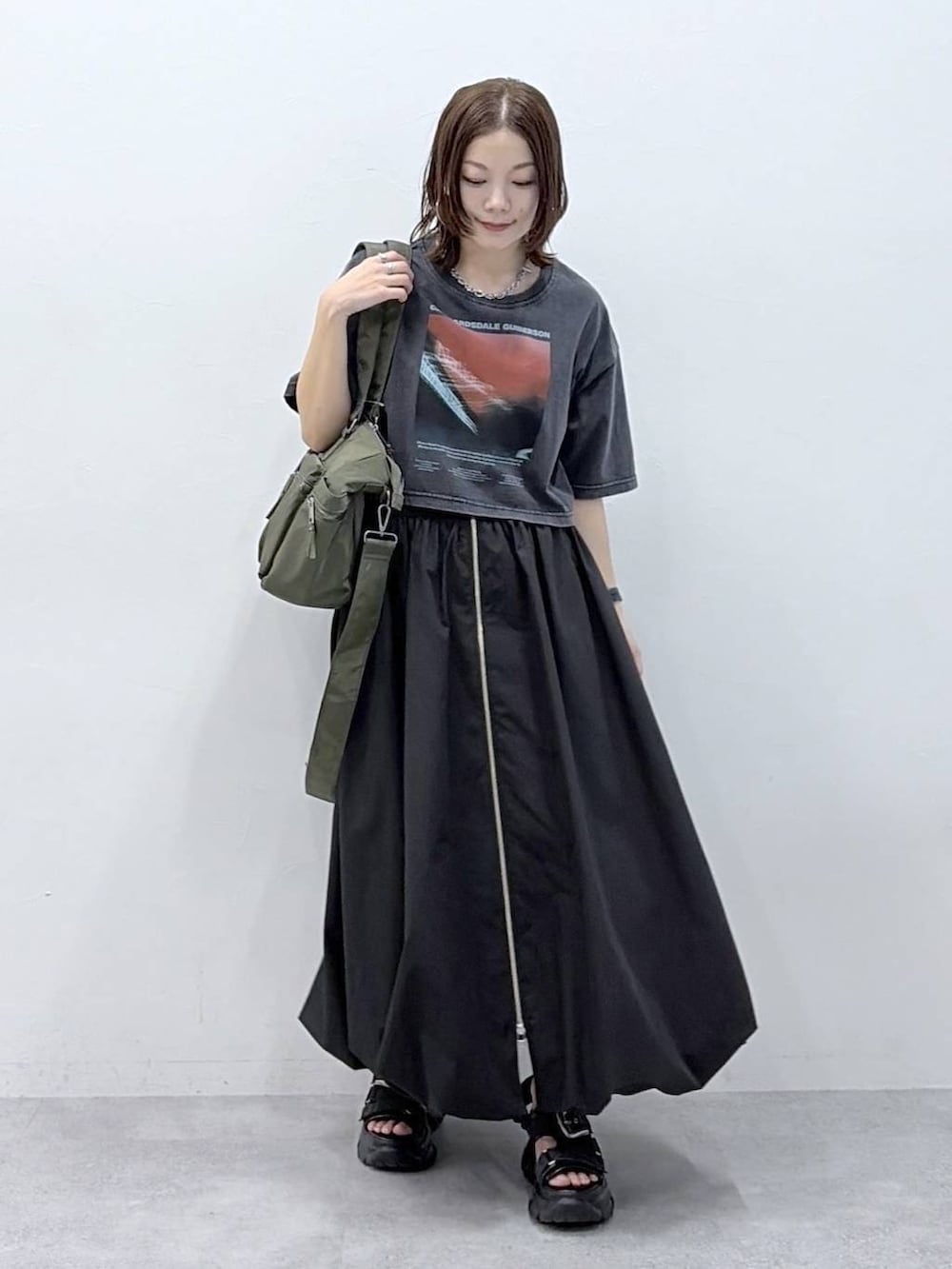 グリーン系のボストンバッグ、ブラック系のサンダル、ブラック系のスカートを着用したレディースの春コーディネートの9枚目の写真