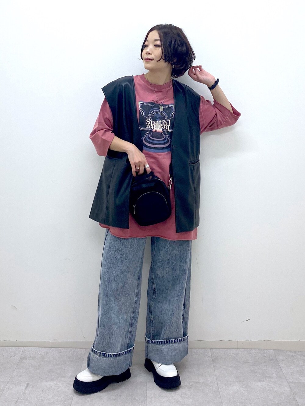 ブルー系のデニムパンツ、ホワイト系のブーツ、ブラック系のショルダーバッグを着用したレディースの秋コーディネートの5枚目の写真