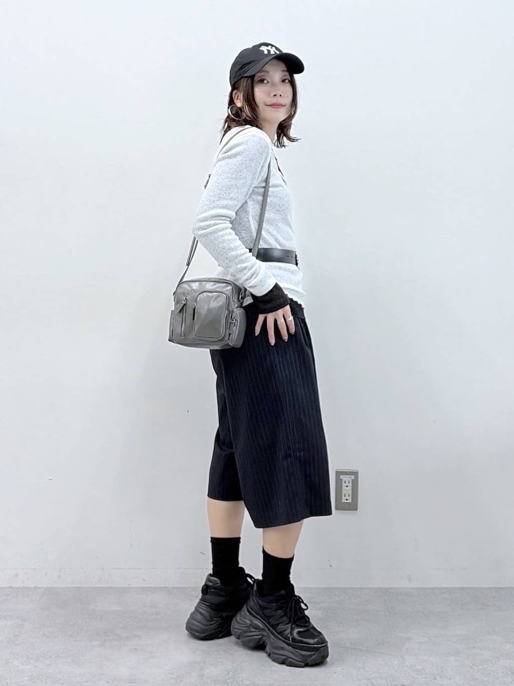 ブラック系のスニーカー、グレー系のショルダーバッグ、ブラック系のTシャツ/カットソーを着用したレディースの春コーディネートの5枚目の写真