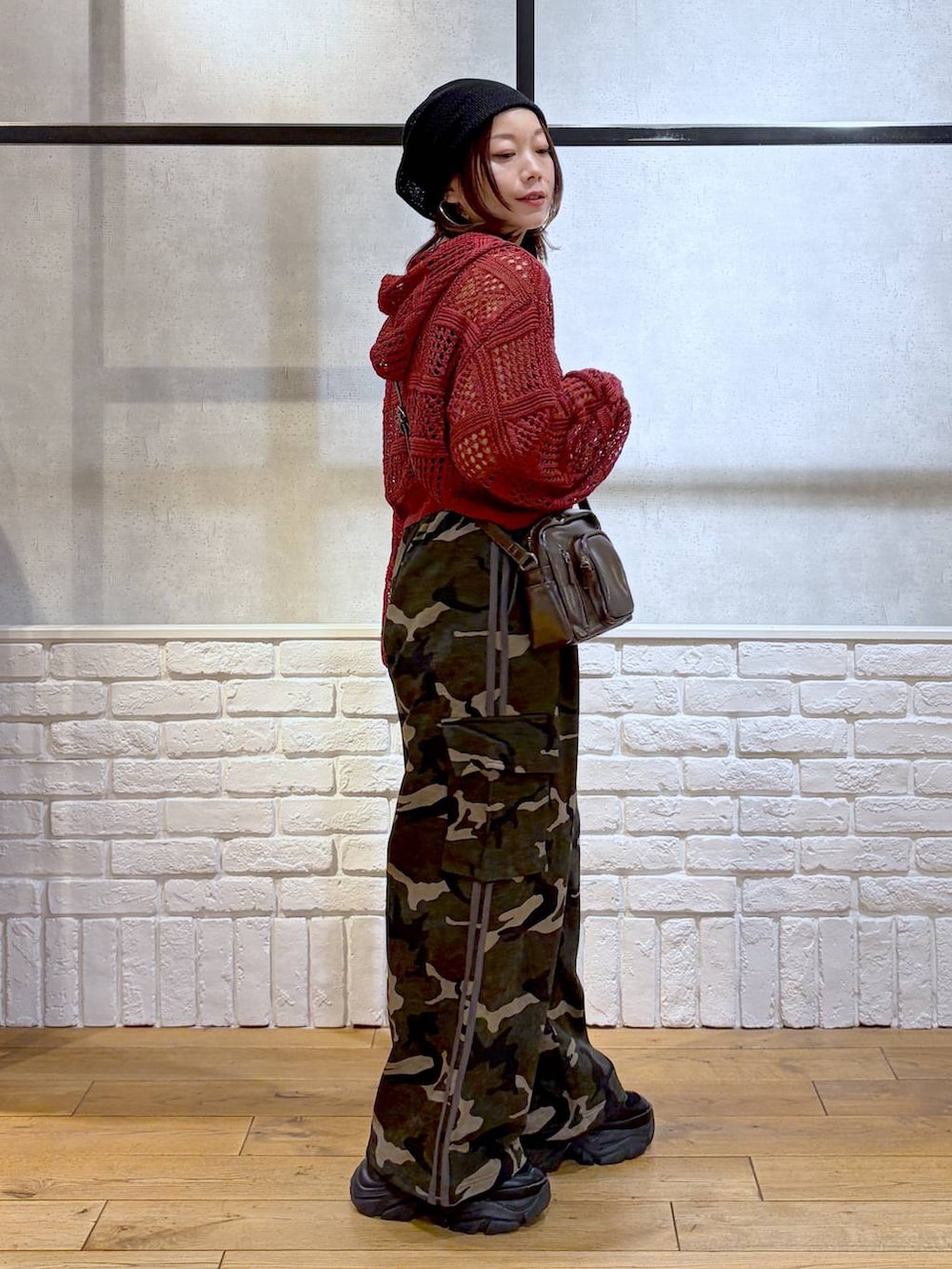 ブラック系のスニーカー、ブラック系のタンクトップ、グリーン系のスウェットパンツを着用したレディースの春コーディネートの5枚目の写真