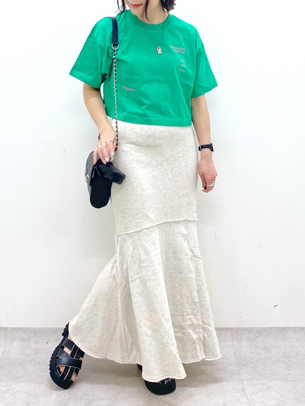 ブラック系のバッグ、ブラック系のサンダル、ベージュ系のスカートを着用したレディースの春コーディネートの5枚目の写真