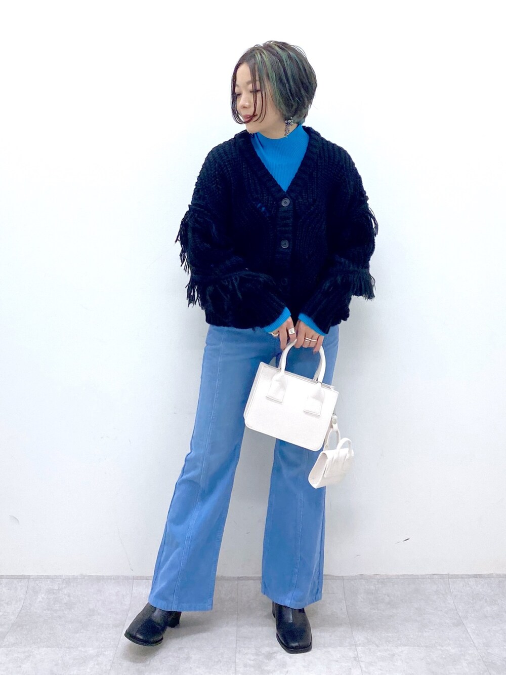 ブルー系のパンツ、ホワイト系のバッグ、ブラック系のシューズを着用したレディースの秋コーディネートの5枚目の写真