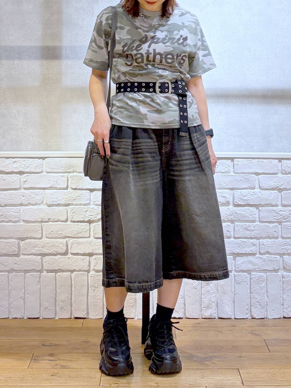 ブラック系のスニーカー、ブラック系のデニムパンツ、グレー系のショルダーバッグを着用したレディースの春コーディネートの2枚目の写真