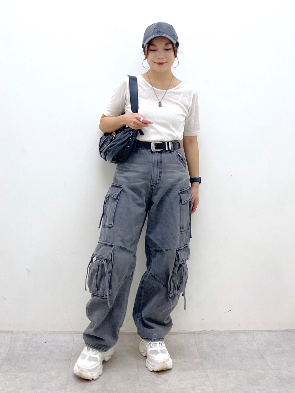 ブラック系のデニムパンツ、ホワイト系のスニーカー、ブラック系のショルダーバッグを着用したレディースの夏コーディネートの9枚目の写真