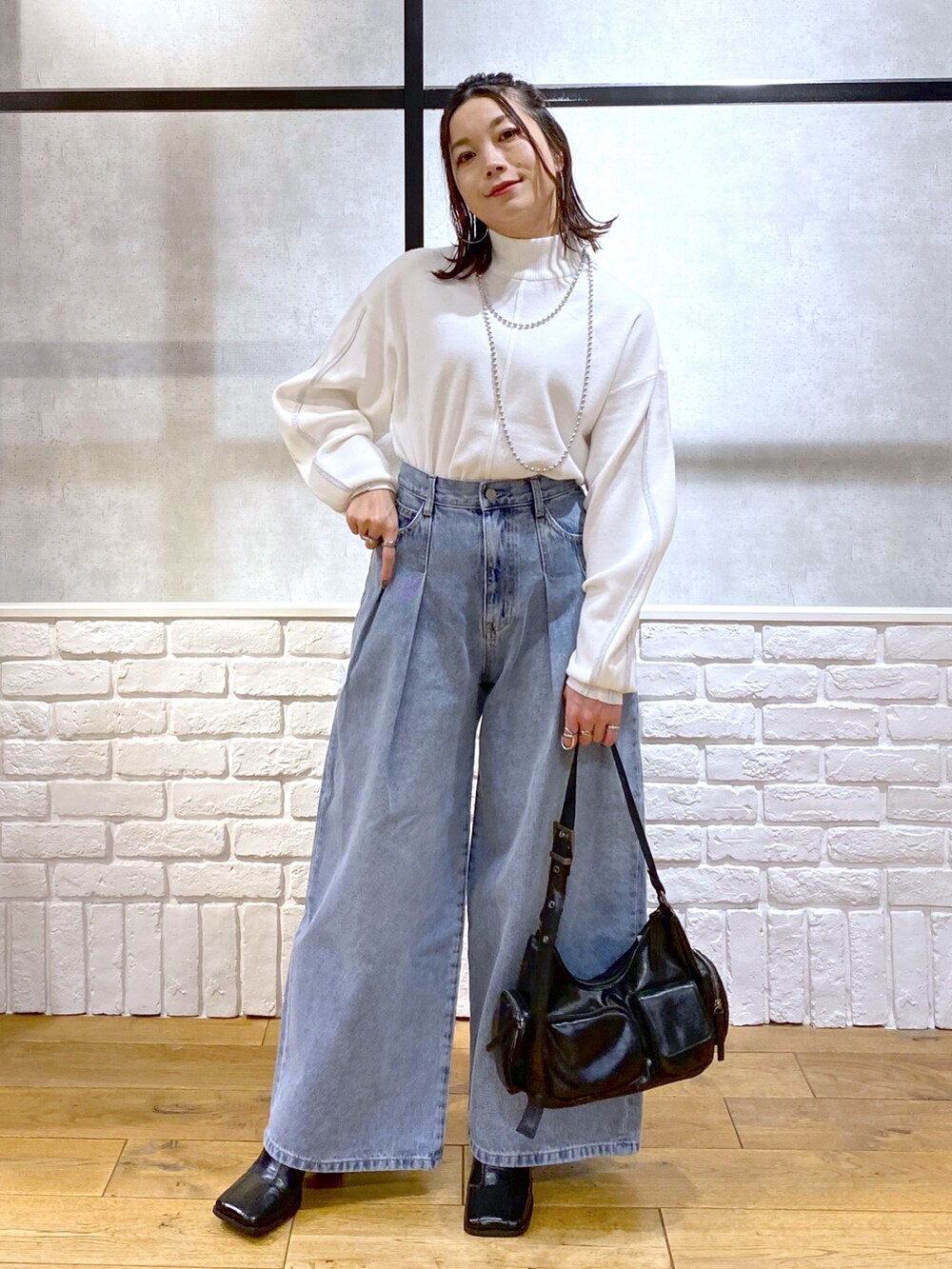 ホワイト系のニット/セーター、ブルー系のデニムパンツ、ブラック系のショルダーバッグを着用したレディースの冬コーディネートの9枚目の写真