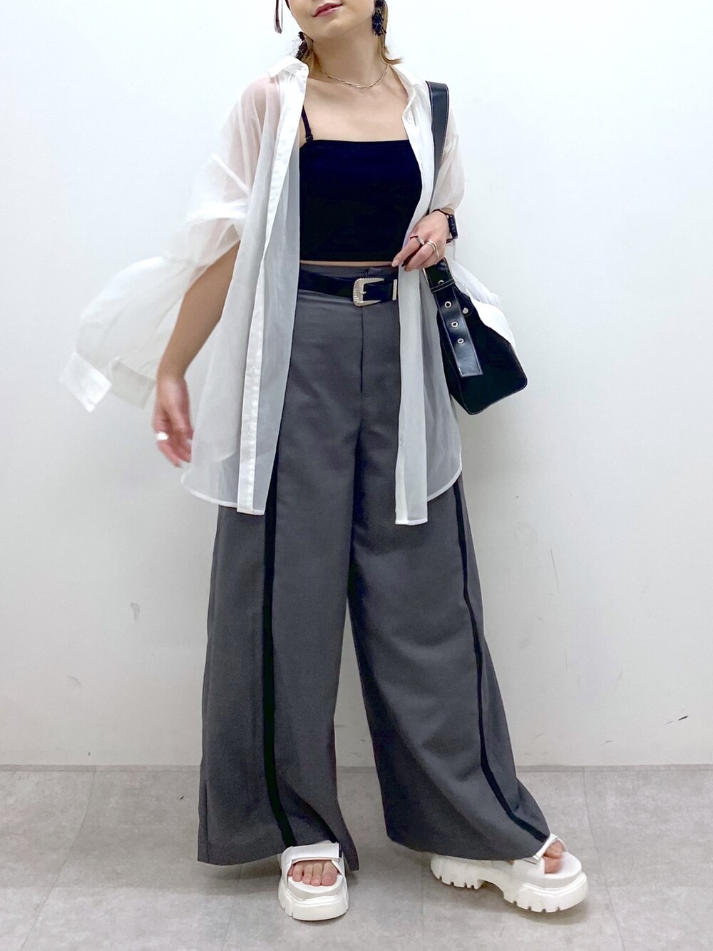 グレー系のスラックス、ブラック系のキャミソール、ブラック系のショルダーバッグを着用したレディースの夏コーディネートの6枚目の写真