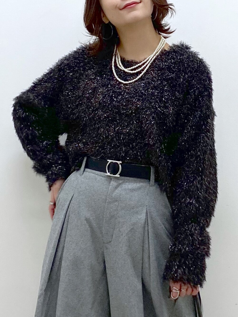 ブラック系のニット/セーター、ブラック系のスラックス、その他のショルダーバッグを着用したレディースの冬コーディネートの2枚目の写真