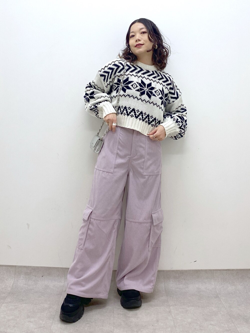ピンク系のカーゴパンツ、ホワイト系のニット/セーター、シルバー系のショルダーバッグを着用したレディースの冬コーディネートの9枚目の写真