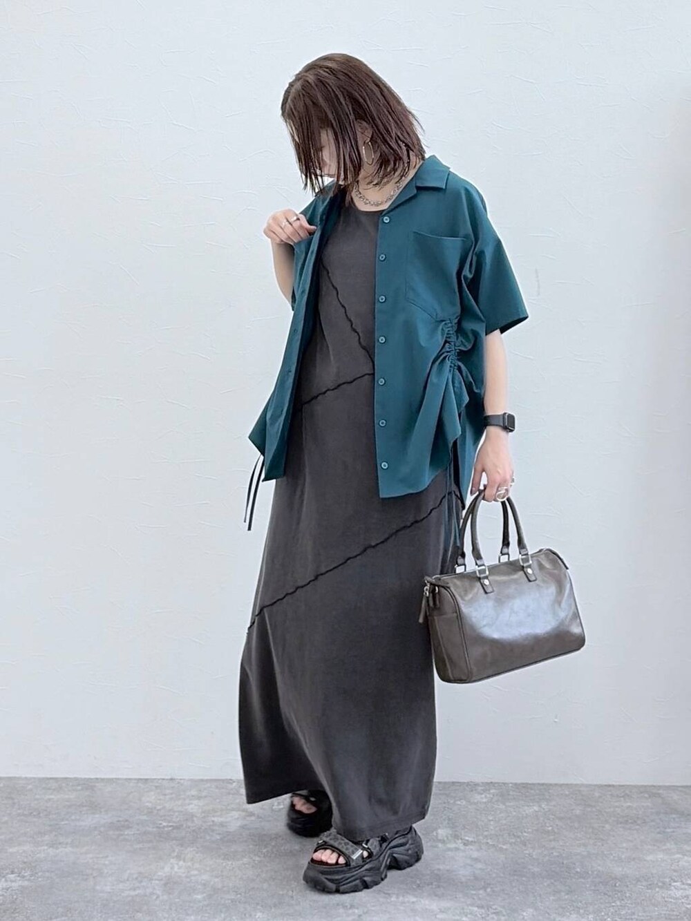 ブラック系のワンピース、グレー系のショルダーバッグ、グリーン系のシャツ/ブラウスを着用したレディースの春コーディネートの8枚目の写真