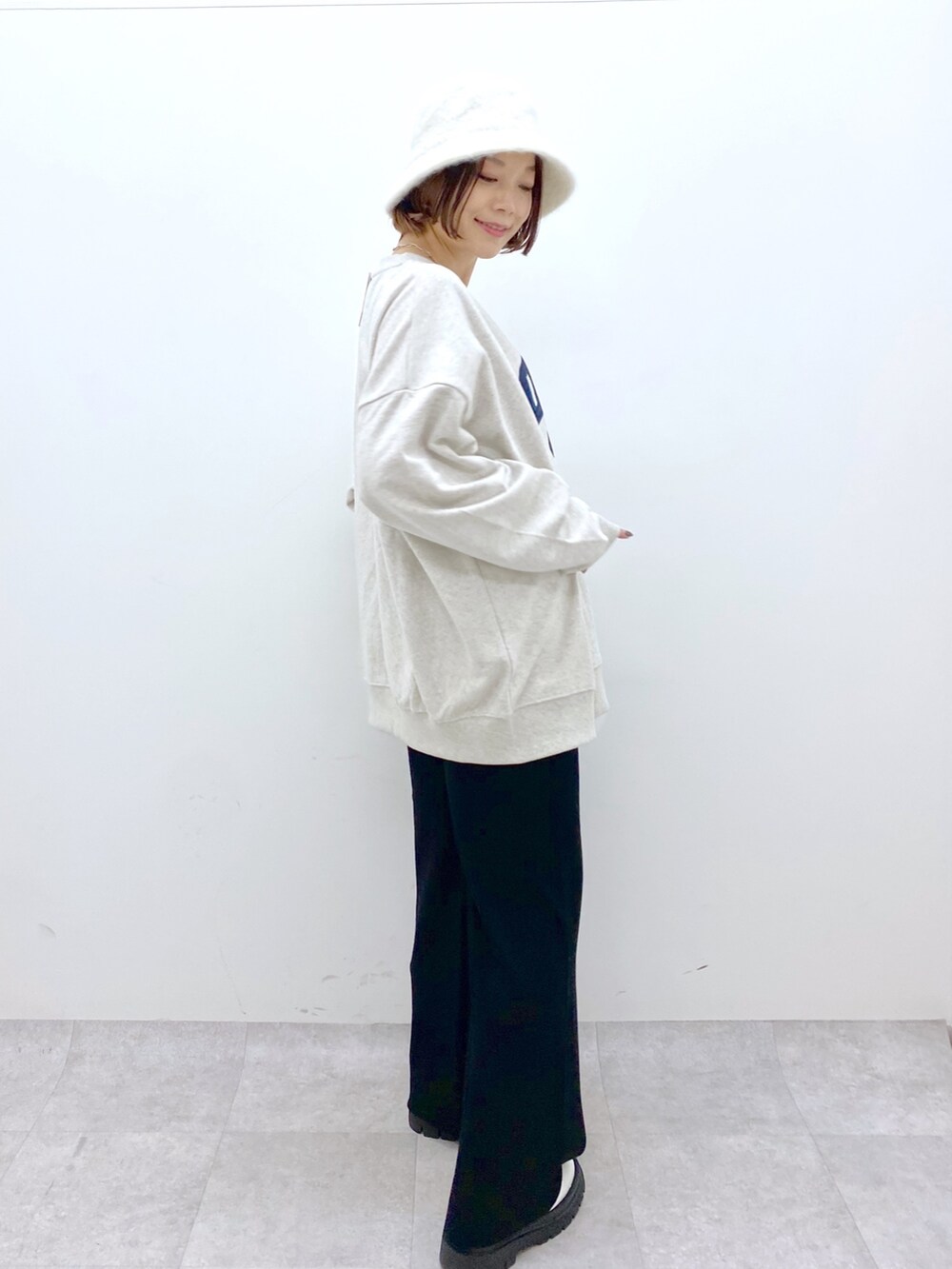 ベージュ系のトップス、ブラック系のパンツ、ホワイト系のシューズを着用したレディースの秋コーディネートの3枚目の写真