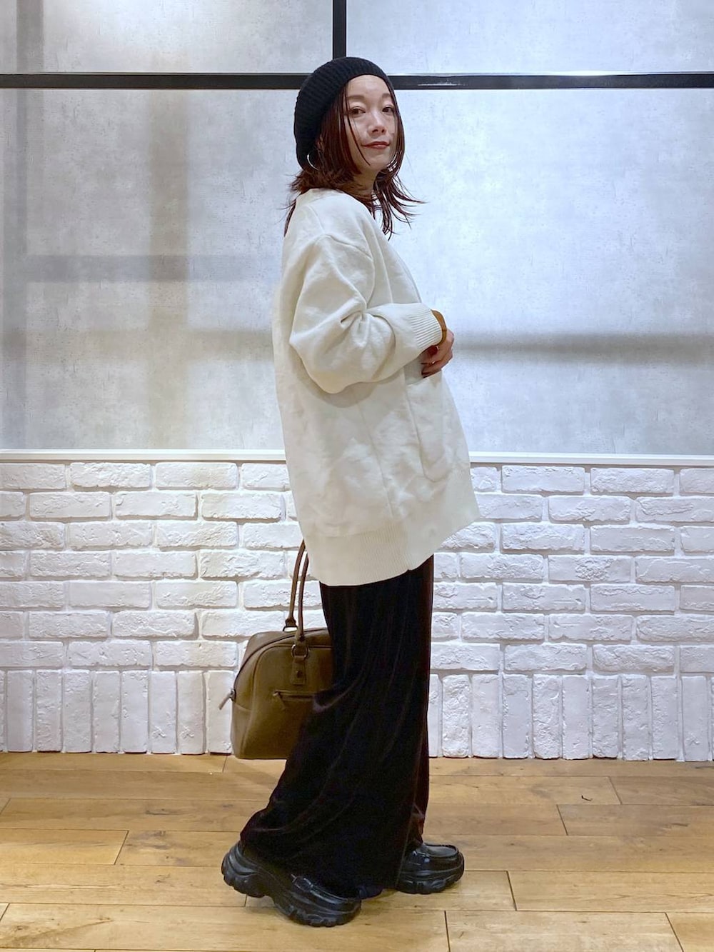 ベージュ系のボストンバッグ、イエロー系のTシャツ/カットソー、ブラック系のローファーを着用したレディースの冬コーディネートの7枚目の写真