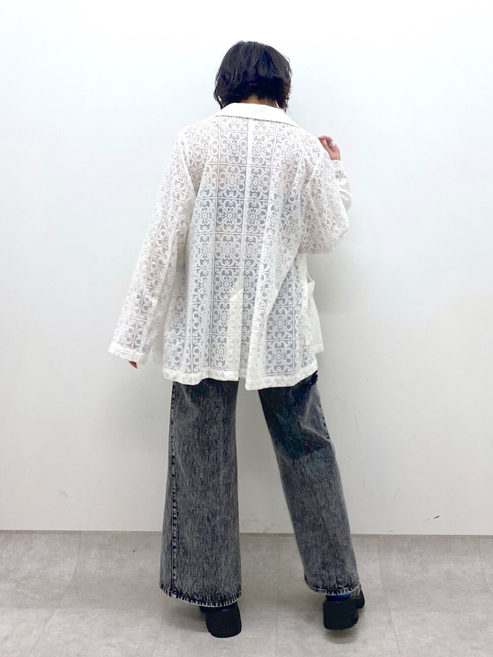 ホワイト系のテーラードジャケット、ブラック系のパンツ、ブラック系のサンダルを着用したレディースの春コーディネートの3枚目の写真