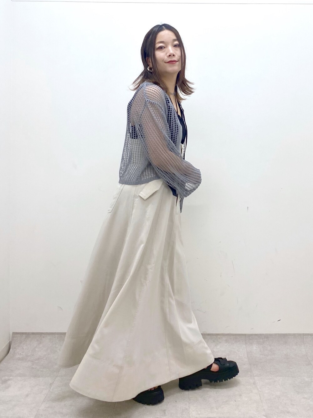 ブラック系のキャミソール、グレー系のカーディガン/ボレロ、ベージュ系のスカートを着用したレディースの春コーディネートの5枚目の写真
