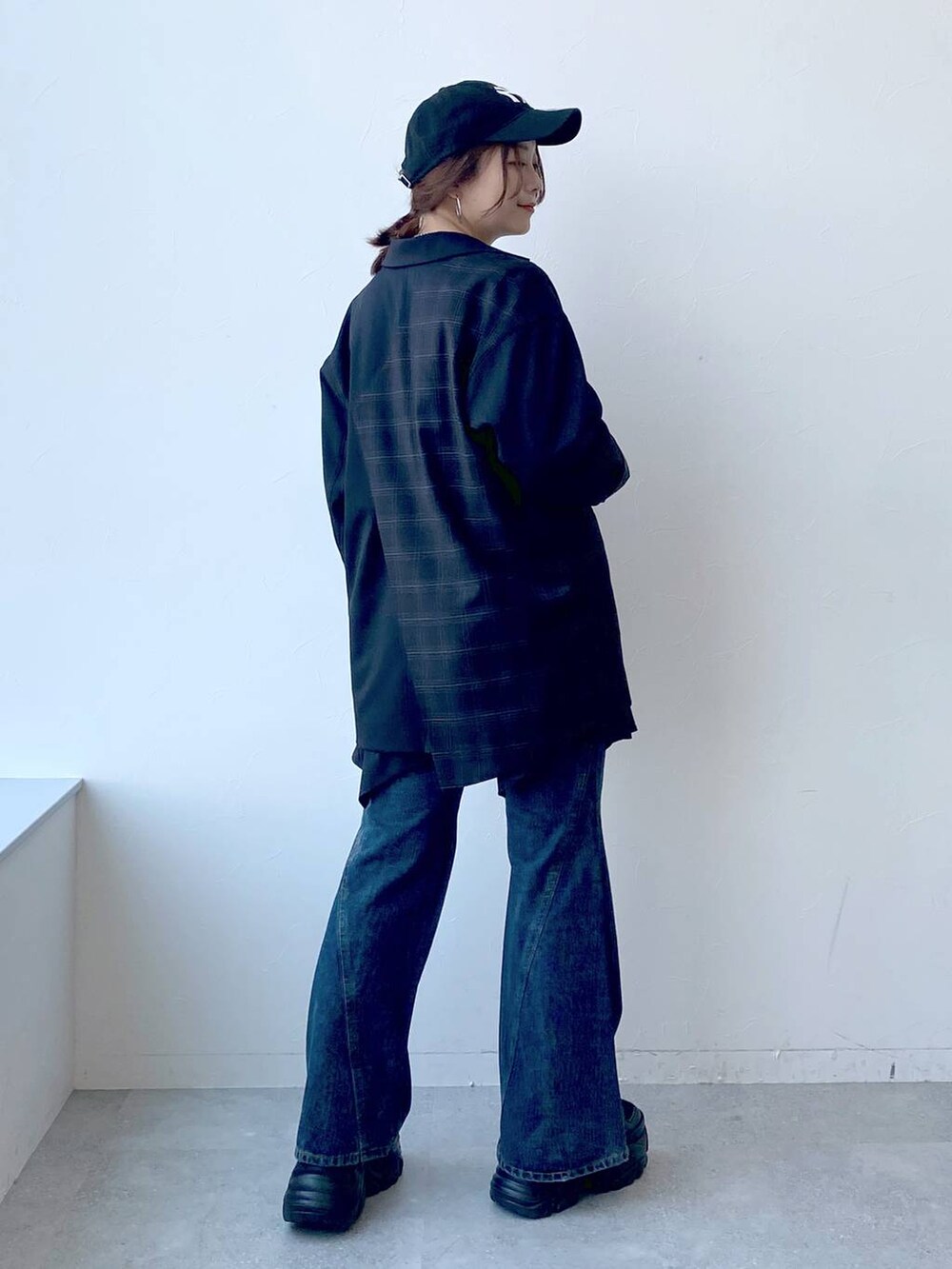 ブラック系のスニーカー、ブルー系のデニムパンツ、ブラック系のスカートを着用したレディースの夏コーディネートの7枚目の写真