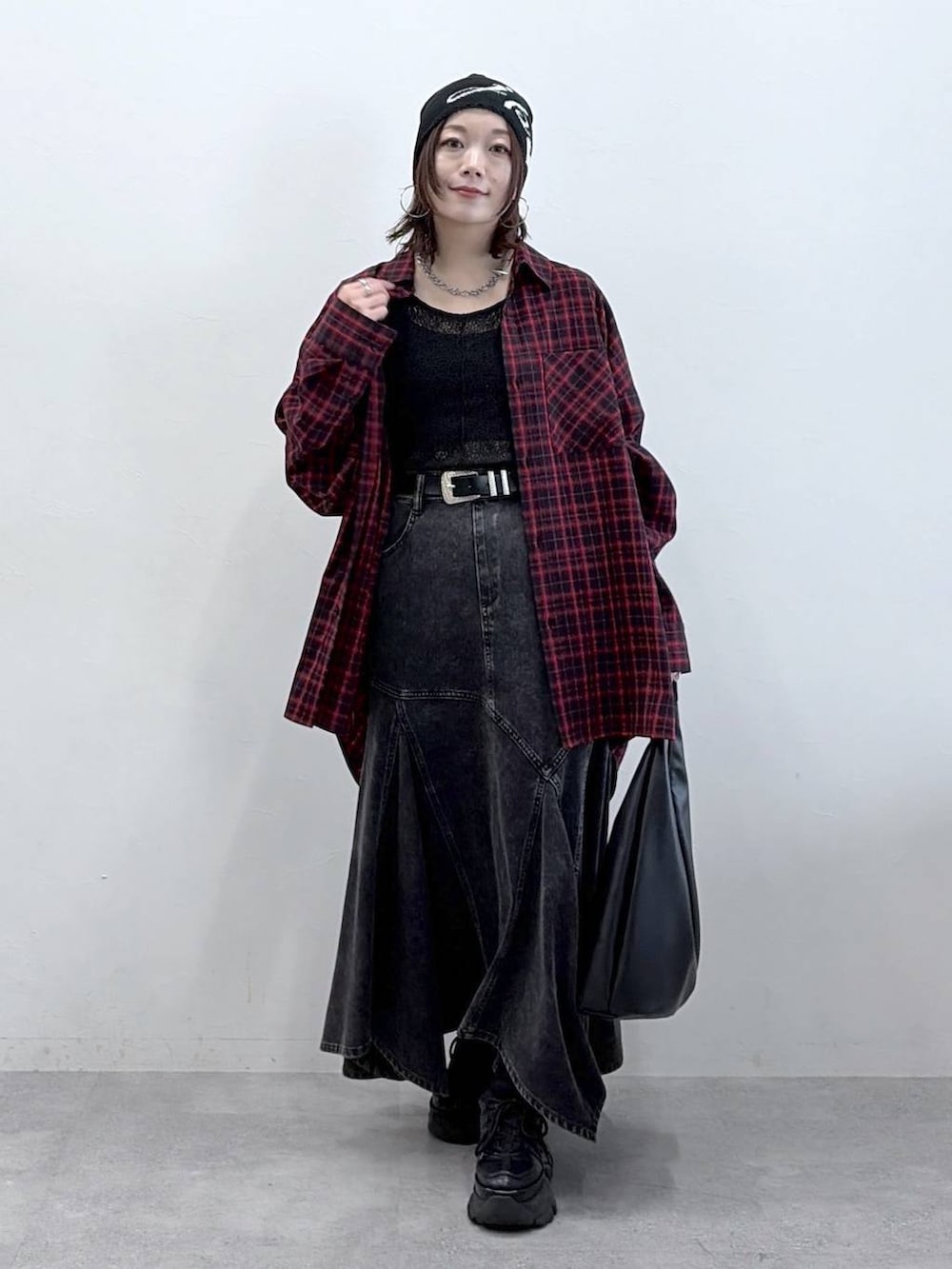 ブラック系のスニーカー、ブラック系のデニムスカート、ブラック系のトートバッグを着用したレディースの春コーディネートの4枚目の写真