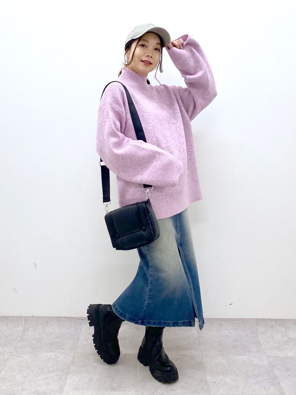 レッド系のニット/セーター、ブルー系のスカート、ブラック系のブーツを着用したレディースの秋コーディネートの6枚目の写真