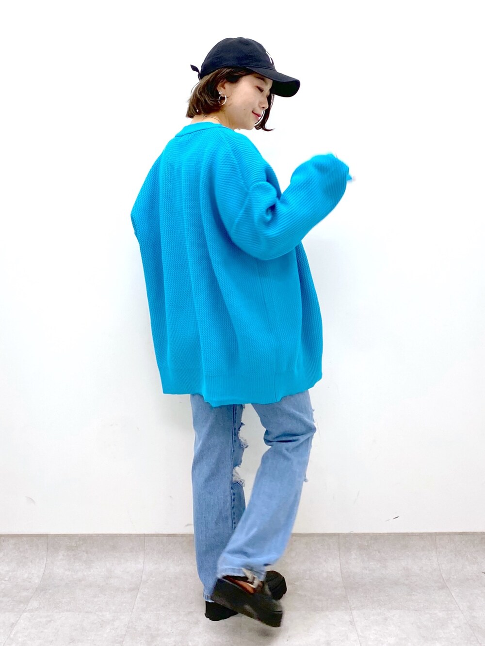 ブラック系のバッグ、ブルー系のパンツ、ブラック系のローファーを着用したレディースの春コーディネートの4枚目の写真