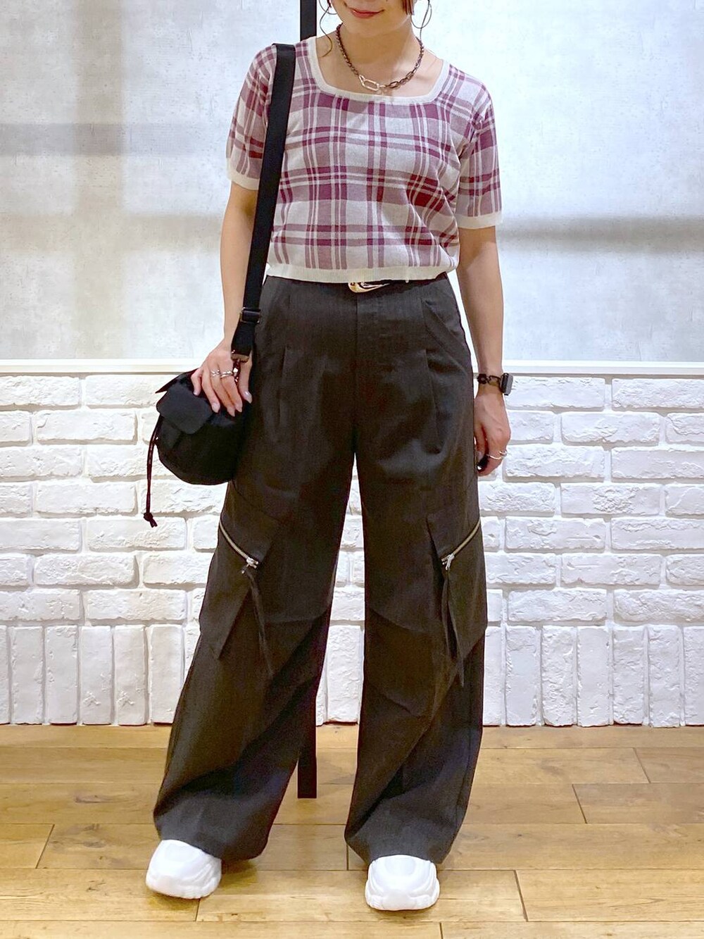 グレー系のカーゴパンツ、ブラック系のショルダーバッグ、ホワイト系のスニーカーを着用したレディースの夏コーディネートの3枚目の写真