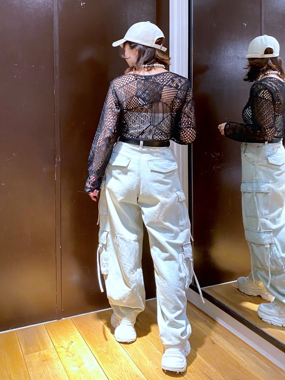 ブルー系のデニムパンツ、ホワイト系のスニーカー、ホワイト系のキャミソールを着用したレディースの夏コーディネートの5枚目の写真