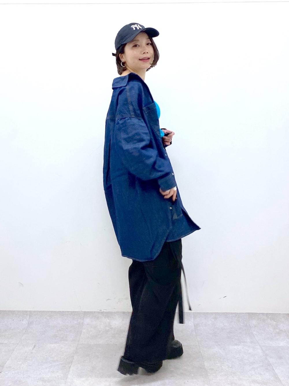 ブラック系のパンツ、ブルー系のトップス、その他のトップスを着用したレディースの春コーディネートの2枚目の写真