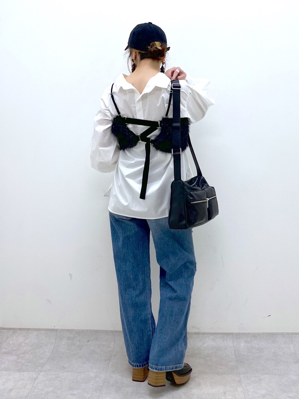 ブルー系のデニムパンツ、ホワイト系のシャツ/ブラウス、ブラック系のベストを着用したレディースの秋コーディネートの5枚目の写真