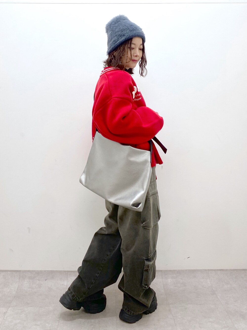 ブラック系のデニムパンツ、ブラック系のブーツ、シルバー系のトートバッグを着用したレディースの秋コーディネートの7枚目の写真