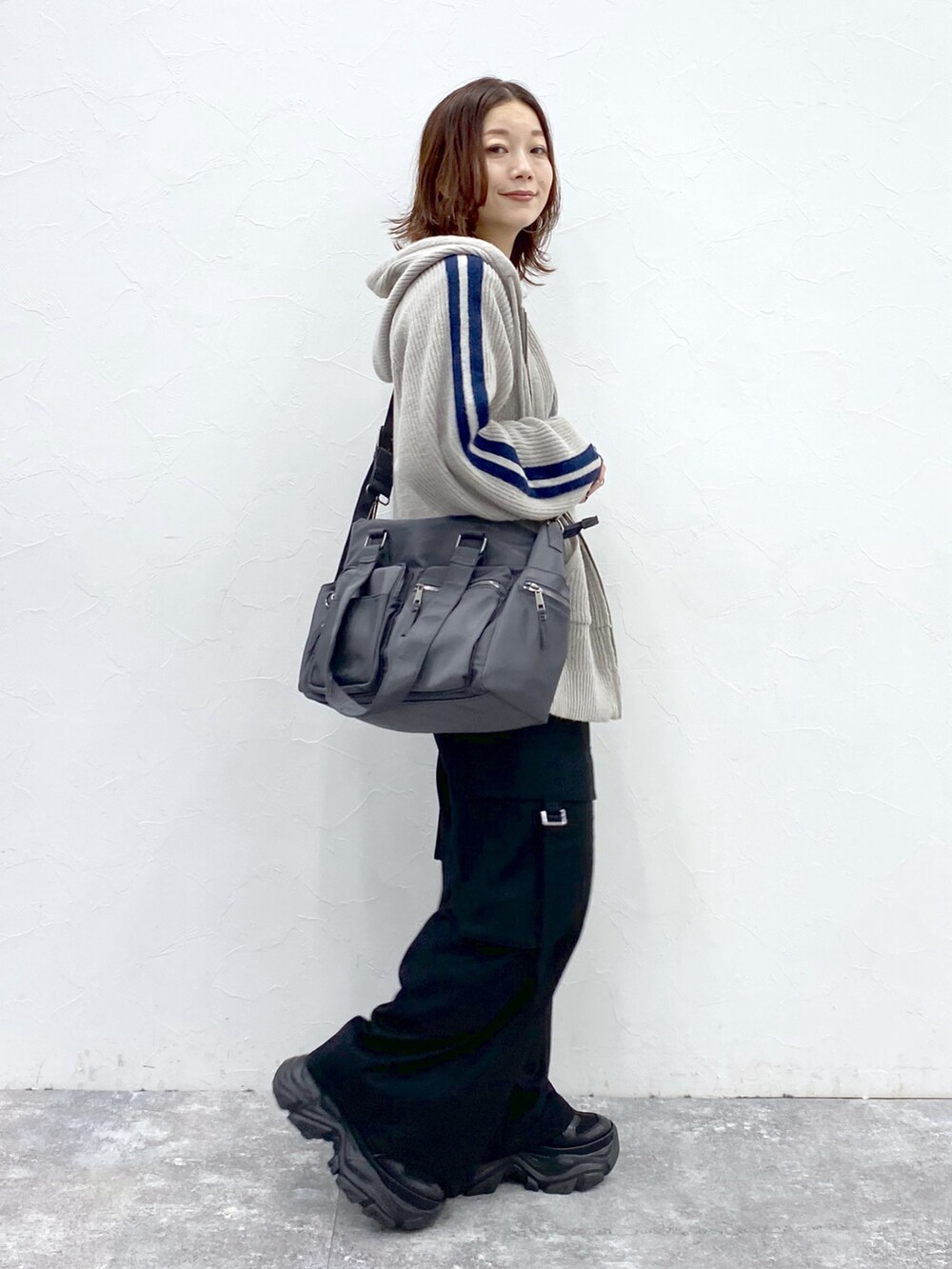 グレー系のニット/セーター、ブラック系のTシャツ/カットソー、ブラック系のスラックスを着用したレディースの秋コーディネートの5枚目の写真