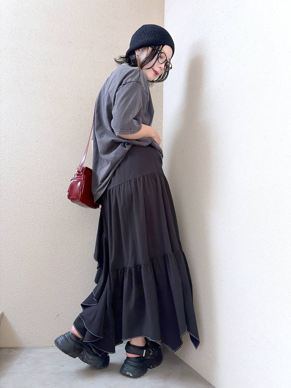 グレー系のTシャツ/カットソー、ブラック系のスカート、レッド系のショルダーバッグを着用したレディースの夏コーディネートの7枚目の写真