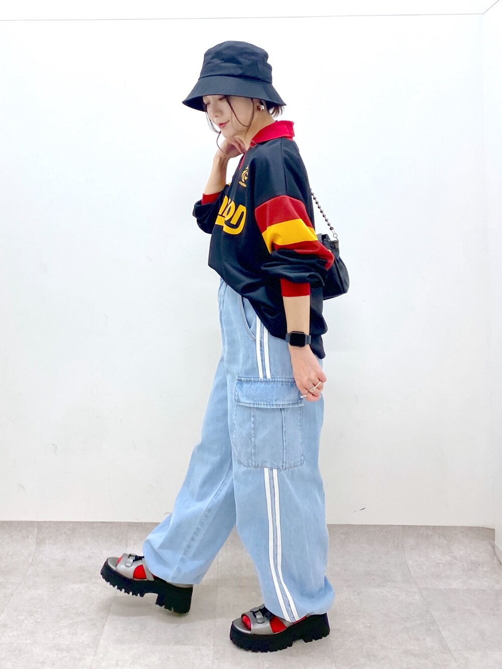 ブラック系のシャツ/ブラウス、ブルー系のデニムパンツ、ブラック系のショルダーバッグを着用したレディースの春コーディネートの7枚目の写真