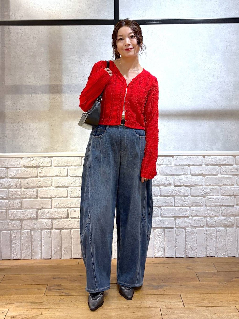 ホワイト系のキャミソール、ブラック系のハンドバッグ、ブラウン系のサンダルを着用したレディースの春コーディネートの4枚目の写真