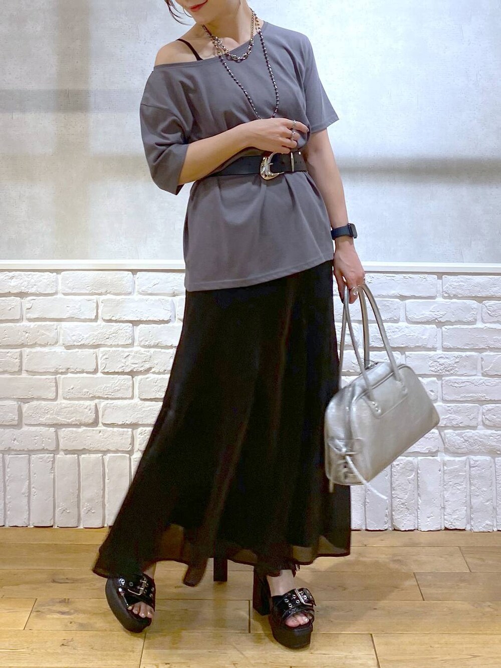 ブラック系のブーツ、シルバー系のショルダーバッグ、グレー系のTシャツ/カットソーを着用したレディースの夏コーディネートの3枚目の写真