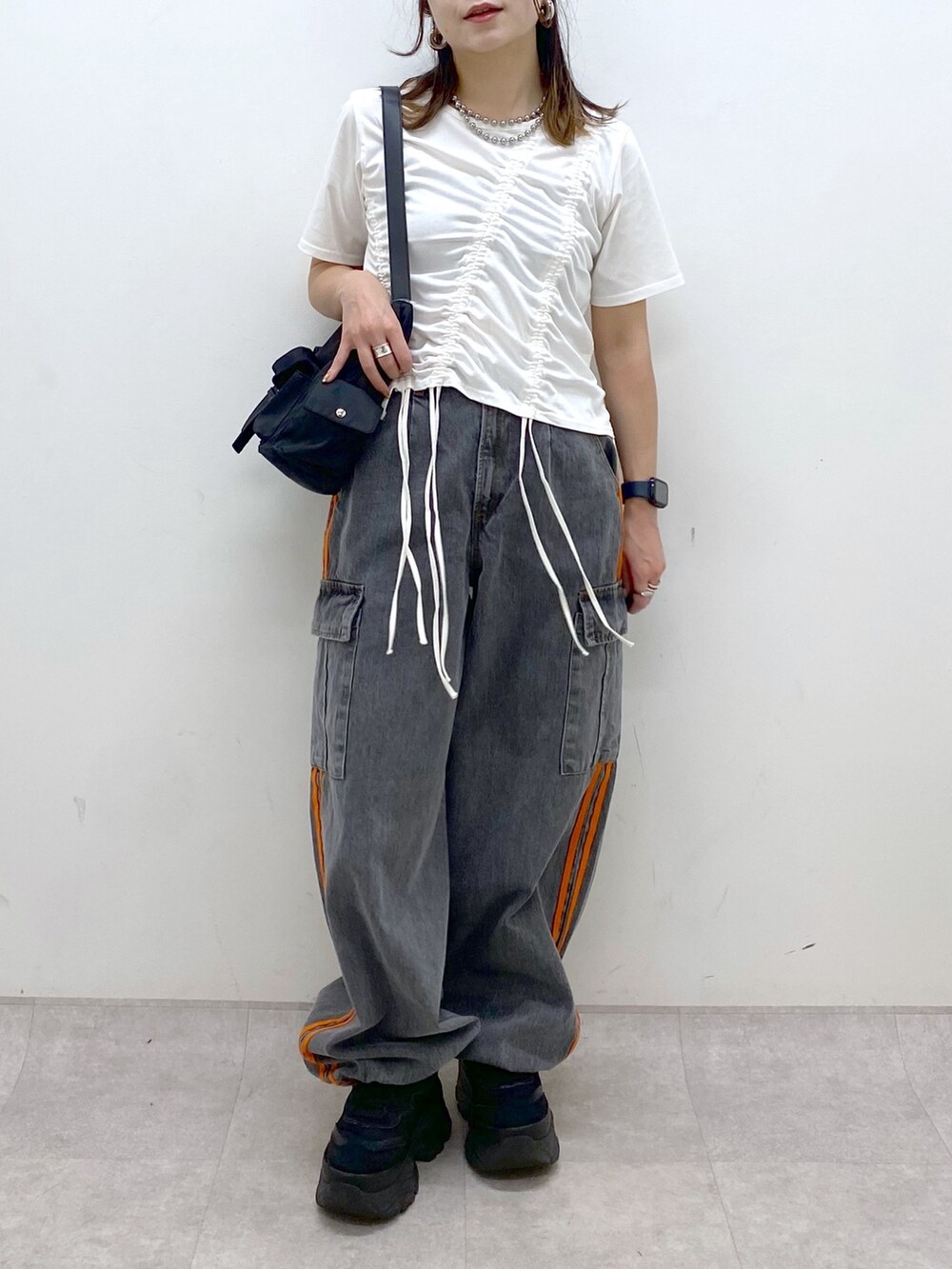 ホワイト系のTシャツ/カットソー、ブラック系のデニムパンツ、ブラック系のスニーカーを着用したレディースの春コーディネートの3枚目の写真