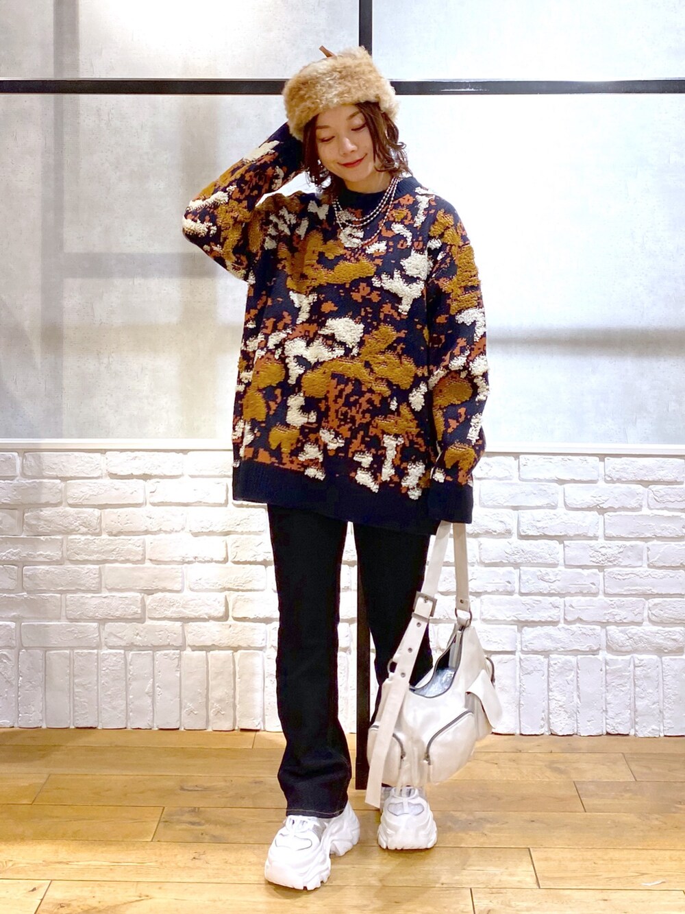 ブルー系のニット/セーター、ブルー系のデニムパンツ、ホワイト系のショルダーバッグを着用したレディースの冬コーディネートの8枚目の写真