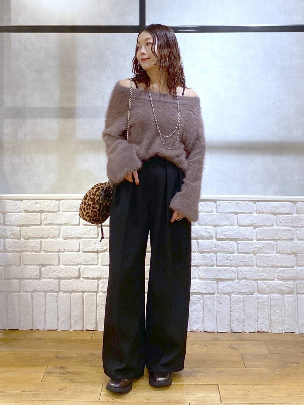 その他のブーツ、ブラック系のスラックス、ブラウン系のニット/セーターを着用したレディースの秋コーディネートの4枚目の写真