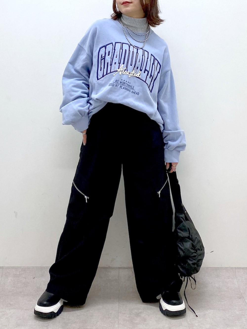 ブルー系のスウェット、ブラック系のカーゴパンツ、ブラック系のブーツを着用したレディースの冬コーディネートの3枚目の写真