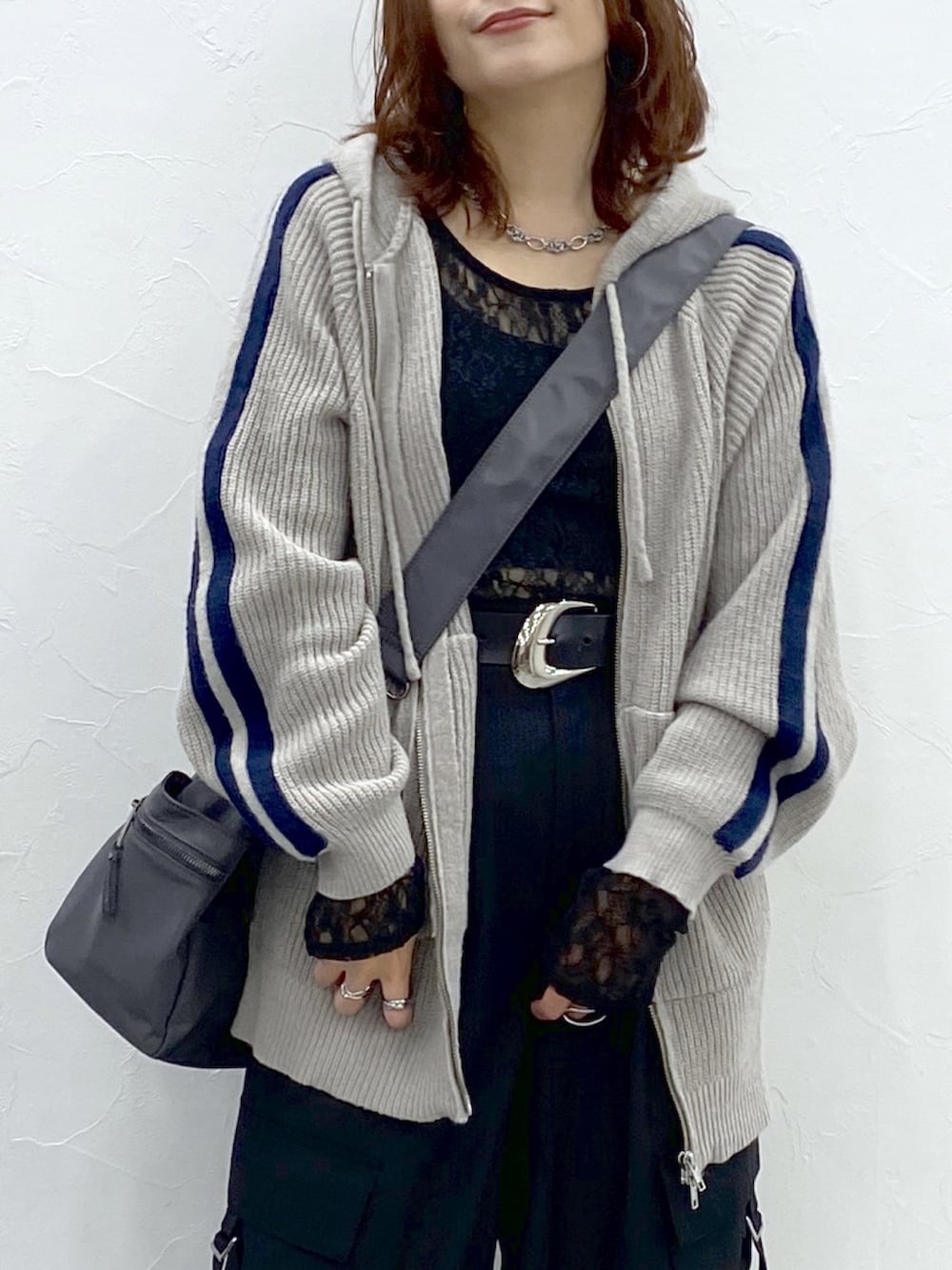 グレー系のニット/セーター、ブラック系のTシャツ/カットソー、ブラック系のスラックスを着用したレディースの秋コーディネートの2枚目の写真