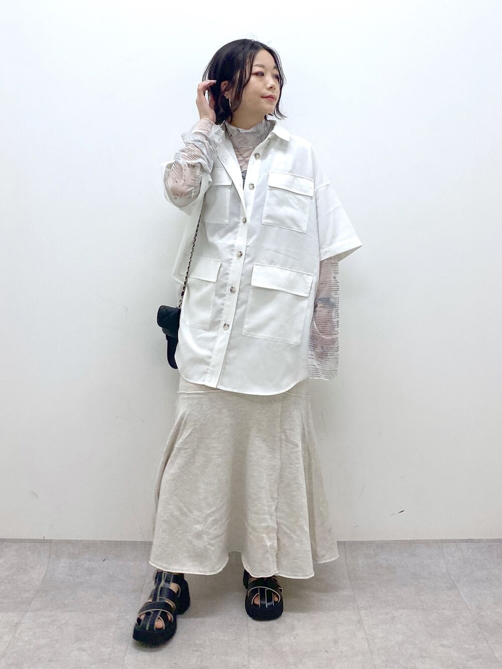 ホワイト系のトップス、ホワイト系のトップス、ブラック系のバッグを着用したレディースの春コーディネートの2枚目の写真