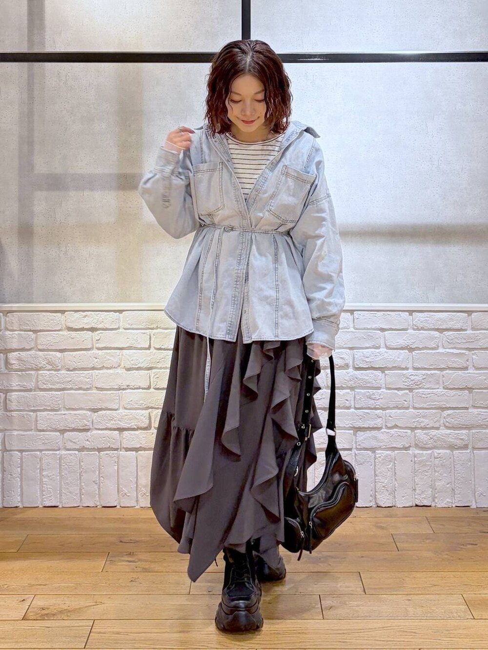 ブラック系のブーツ、ブラック系のショルダーバッグ、グレー系のスカートを着用したレディースの冬コーディネートの8枚目の写真