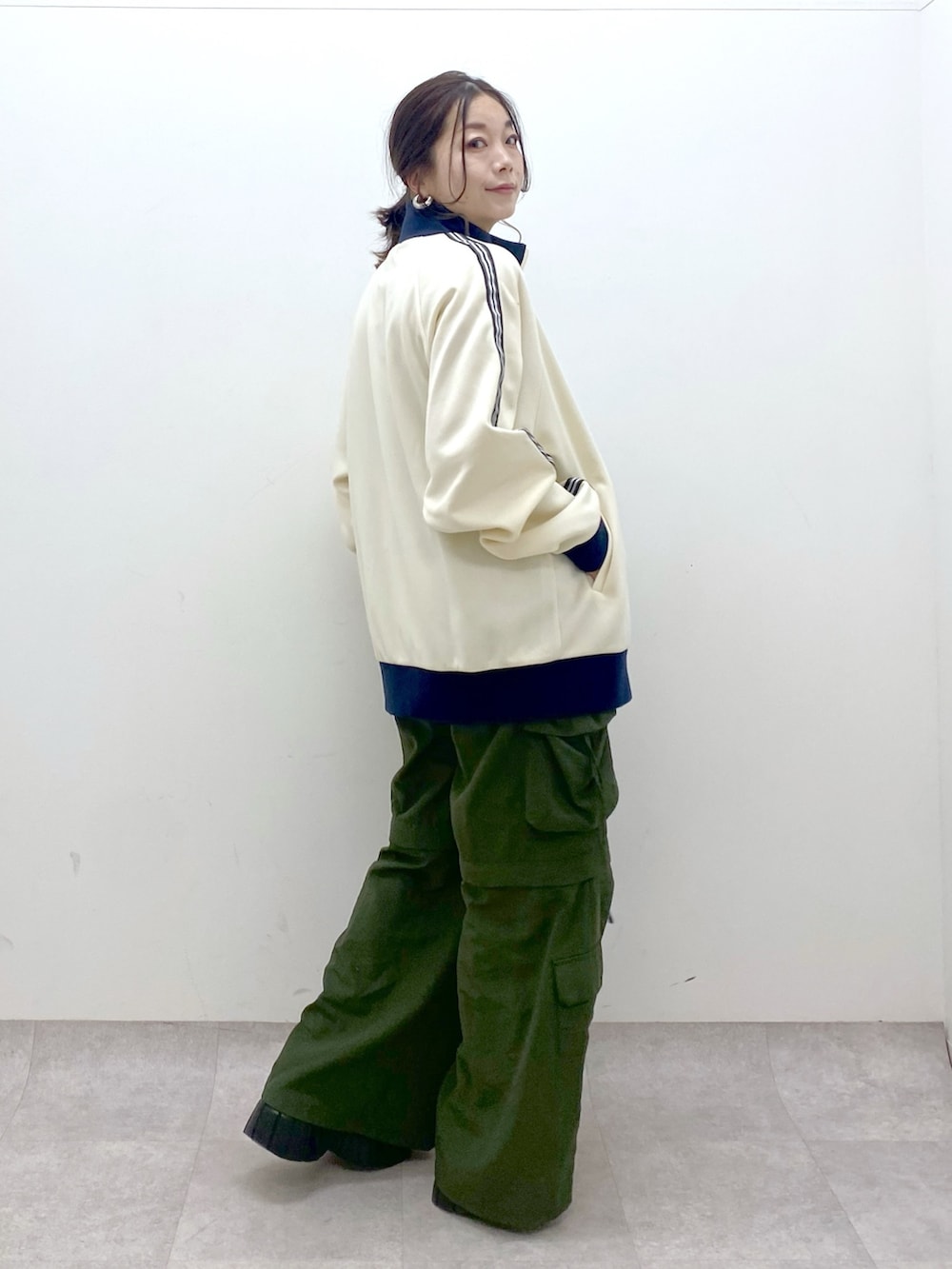 ブラック系のキャミソール、ホワイト系のセットアップ、グリーン系のカーゴパンツを着用したレディースの冬コーディネートの7枚目の写真