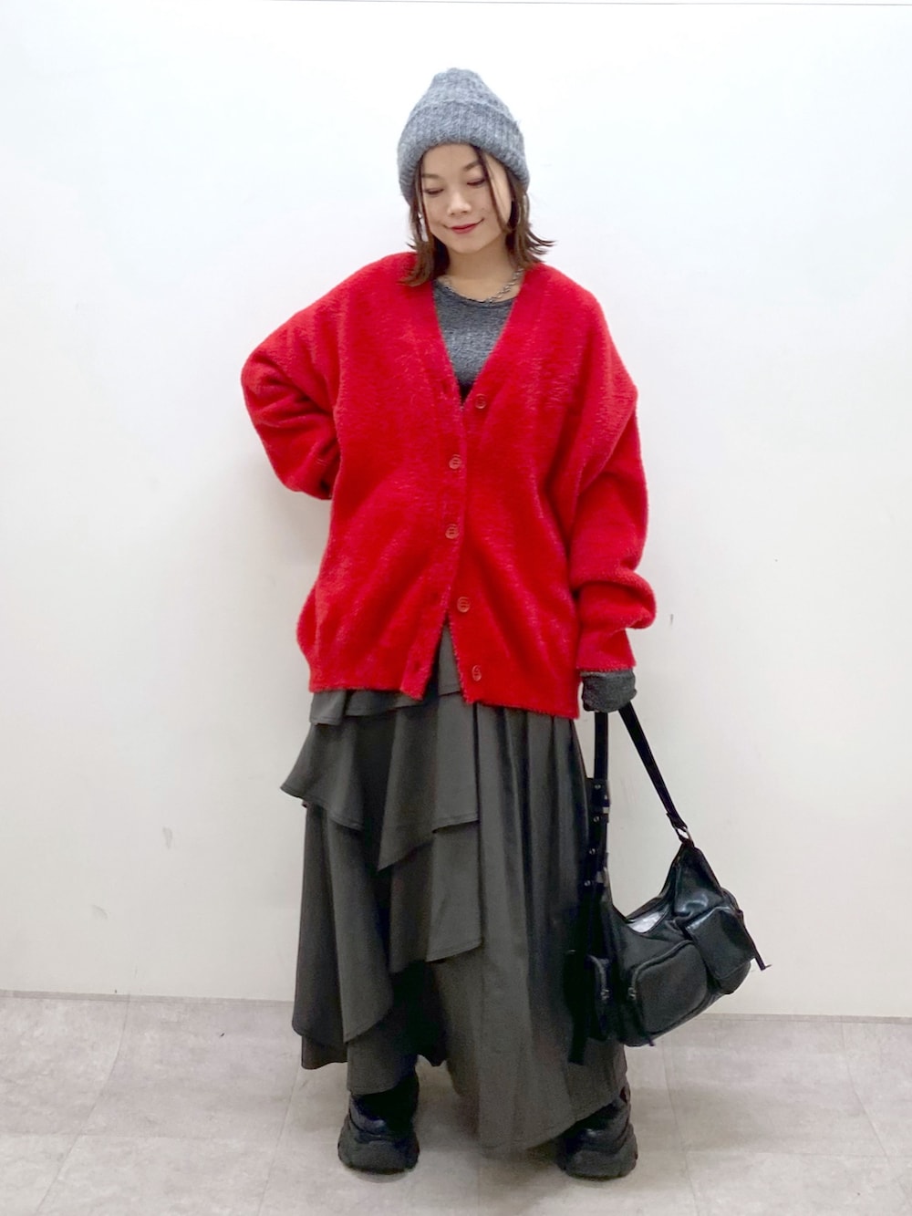 レッド系のカーディガン/ボレロ、シルバー系のTシャツ/カットソー、ブラウン系のスカートを着用したレディースの秋コーディネートの8枚目の写真