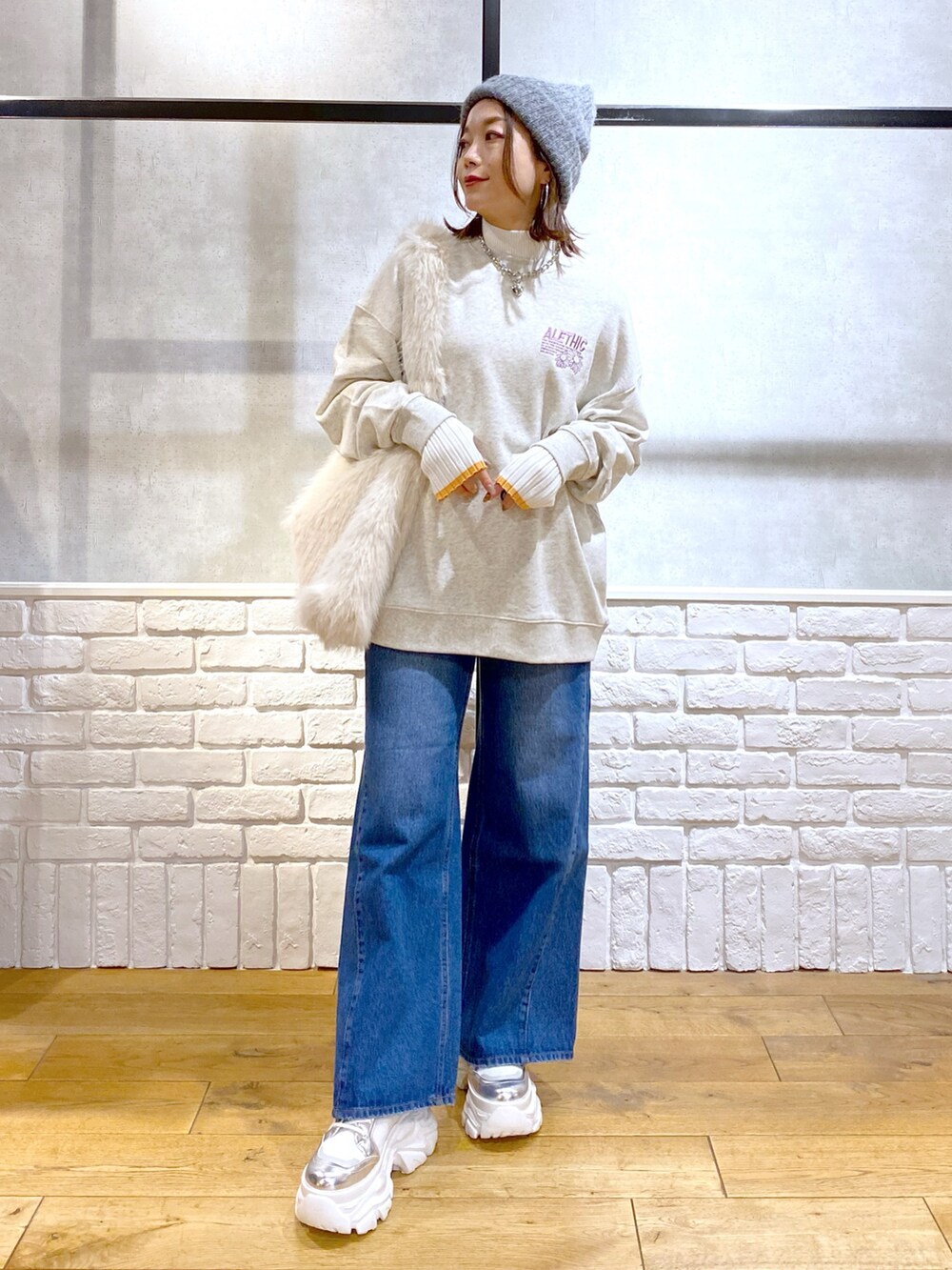 ホワイト系のショルダーバッグ、ブルー系のデニムパンツ、ホワイト系のブーツを着用したレディースの秋コーディネートの9枚目の写真