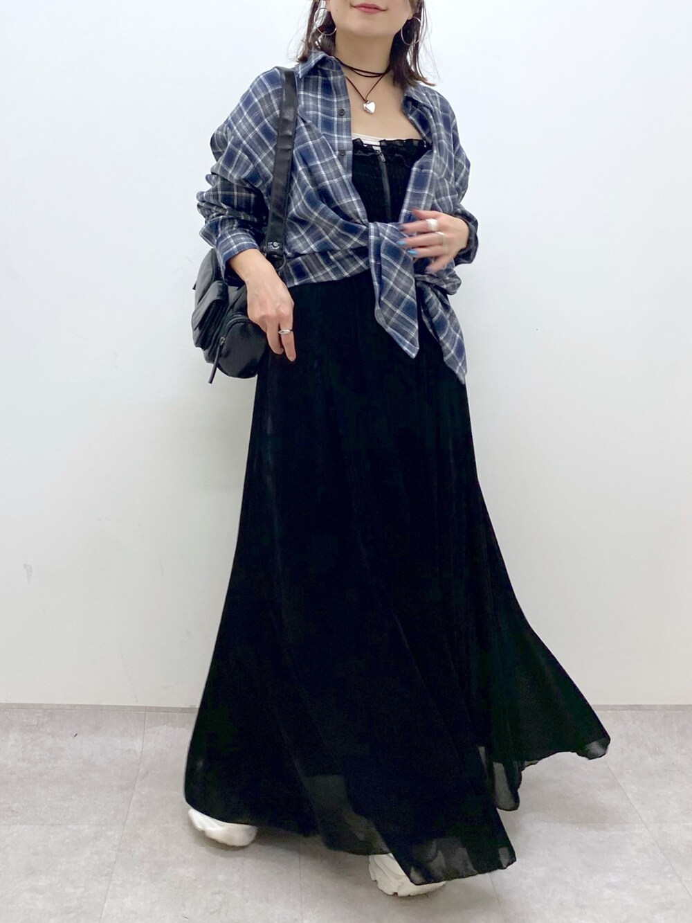 ブラック系のワンピース、ホワイト系のスニーカー、ブラック系のデニムパンツを着用したレディースの夏コーディネートの3枚目の写真