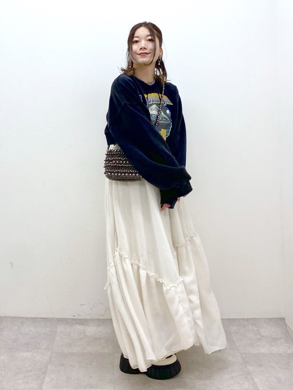 ブラック系のスウェット、ブラック系のショルダーバッグ、ホワイト系のスカートを着用したレディースの冬コーディネートの5枚目の写真