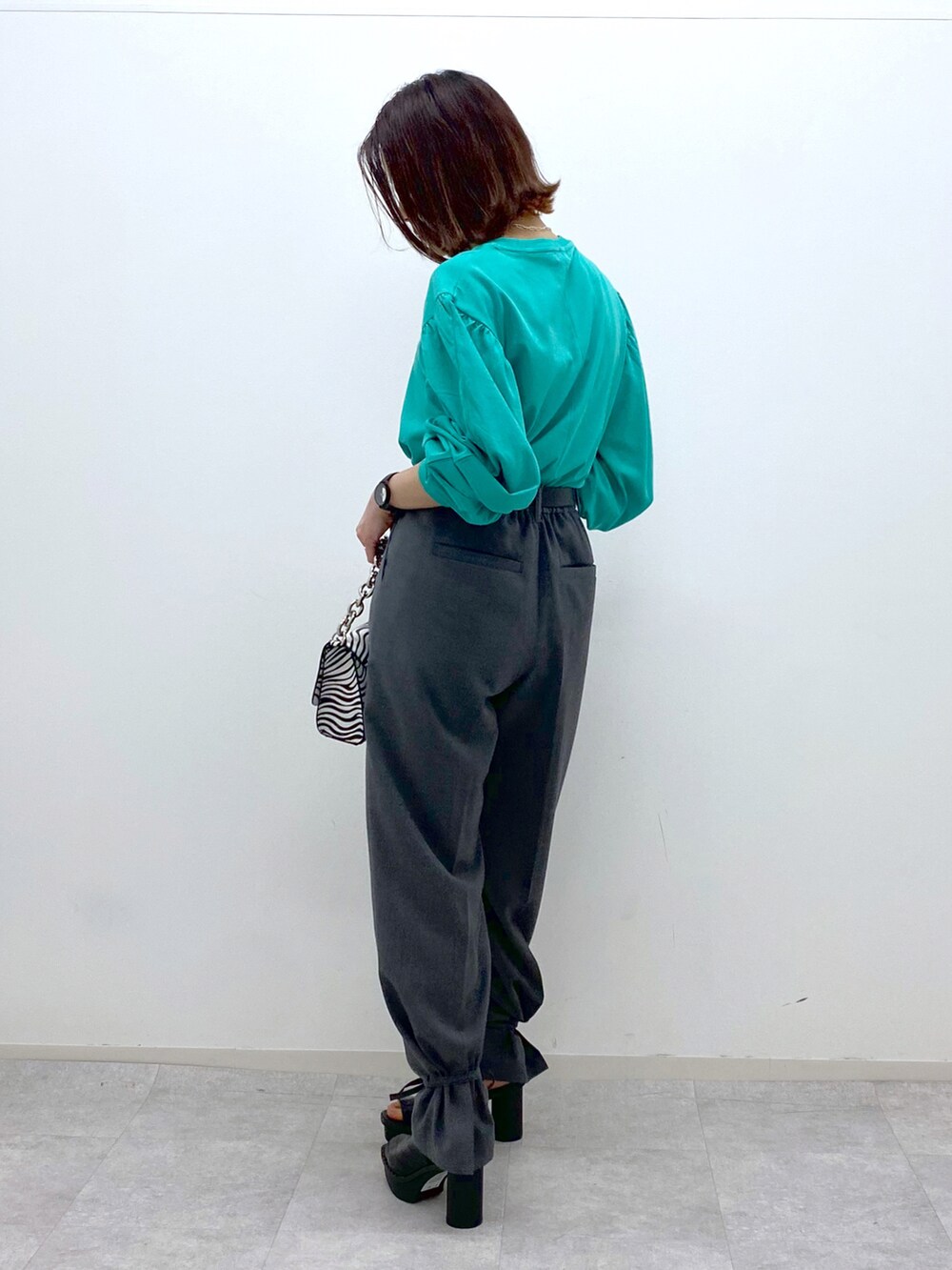 グリーン系のTシャツ/カットソー、グレー系のその他パンツ、その他のショルダーバッグを着用したレディースの春コーディネートの3枚目の写真