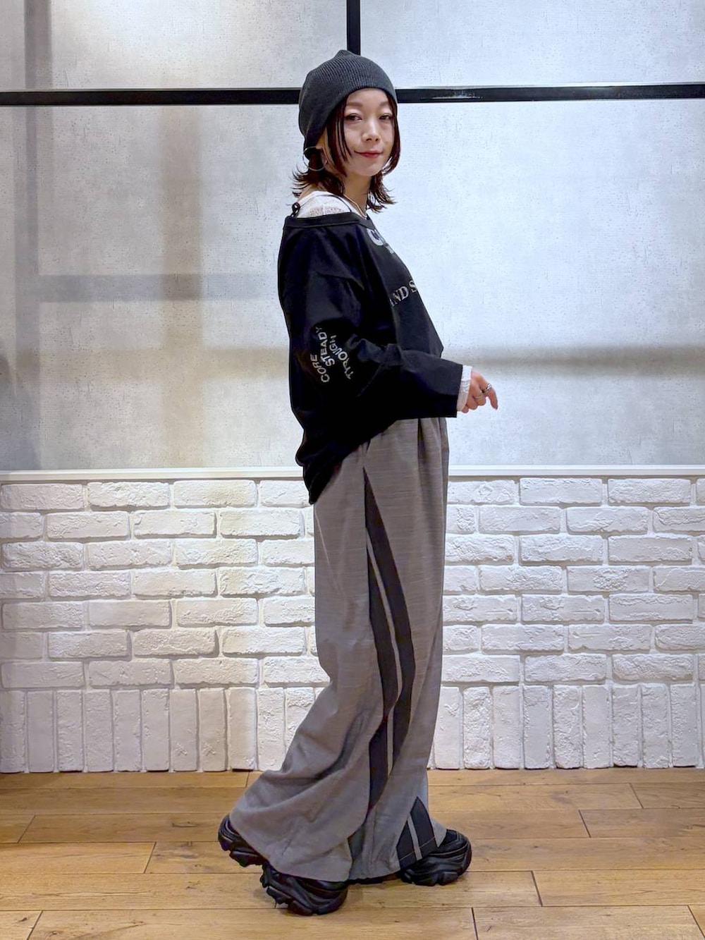 ブラック系のスニーカー、グレー系のその他パンツ、ホワイト系のTシャツ/カットソーを着用したレディースの冬コーディネートの7枚目の写真