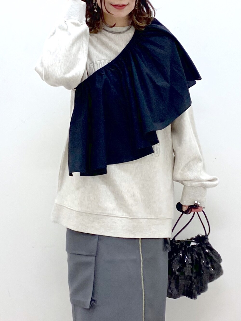 ベージュ系のスウェット、ブラック系のシャツ/ブラウス、ブラック系のショルダーバッグを着用したレディースの冬コーディネートの2枚目の写真