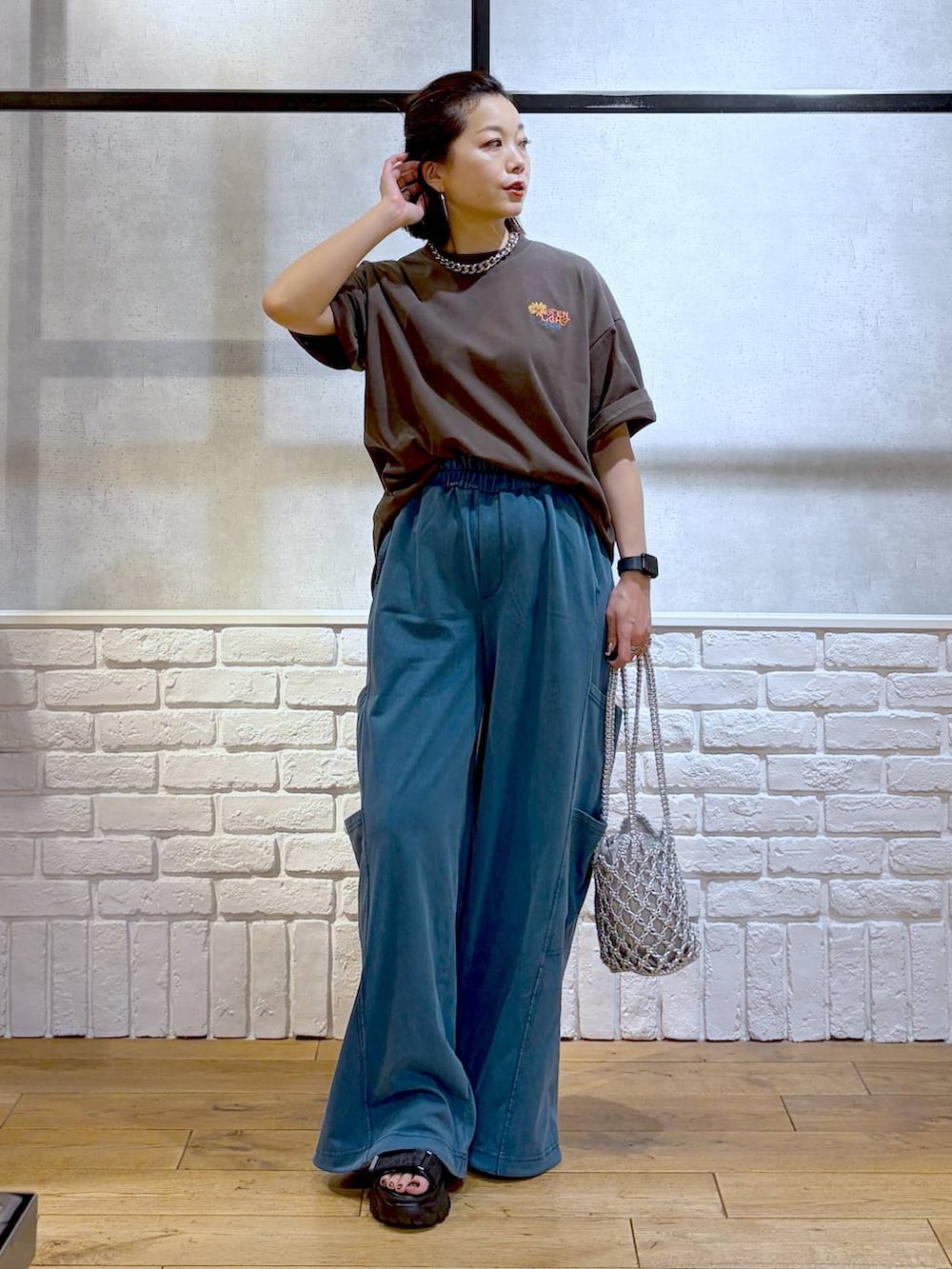 シルバー系のショルダーバッグ、ブラック系のサンダル、ブラウン系のTシャツ/カットソーを着用したレディースの春コーディネートの9枚目の写真