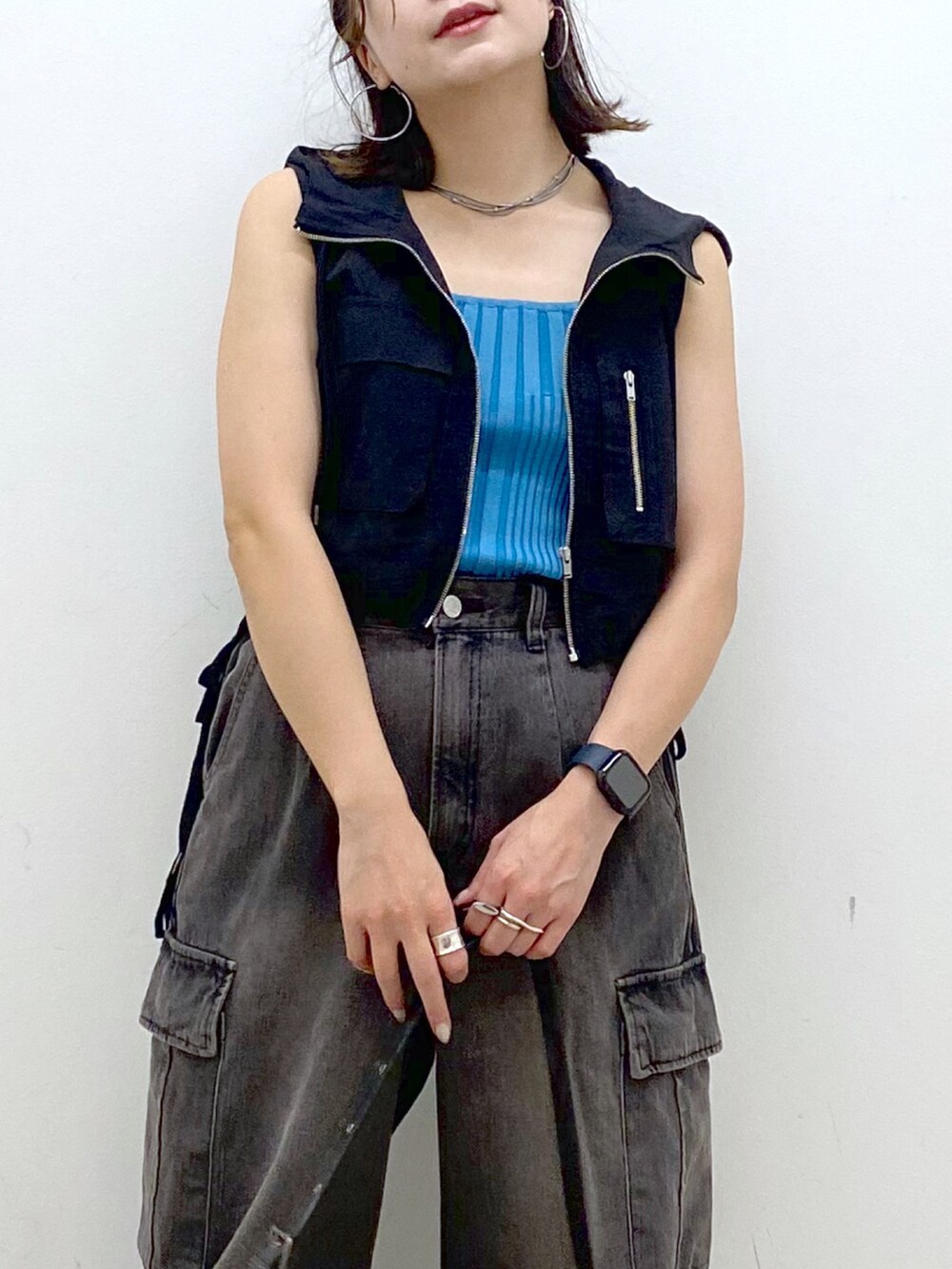 ブラウン系のデニムパンツ、ブラック系のショルダーバッグ、ホワイト系のスニーカーを着用したレディースの夏コーディネートの2枚目の写真